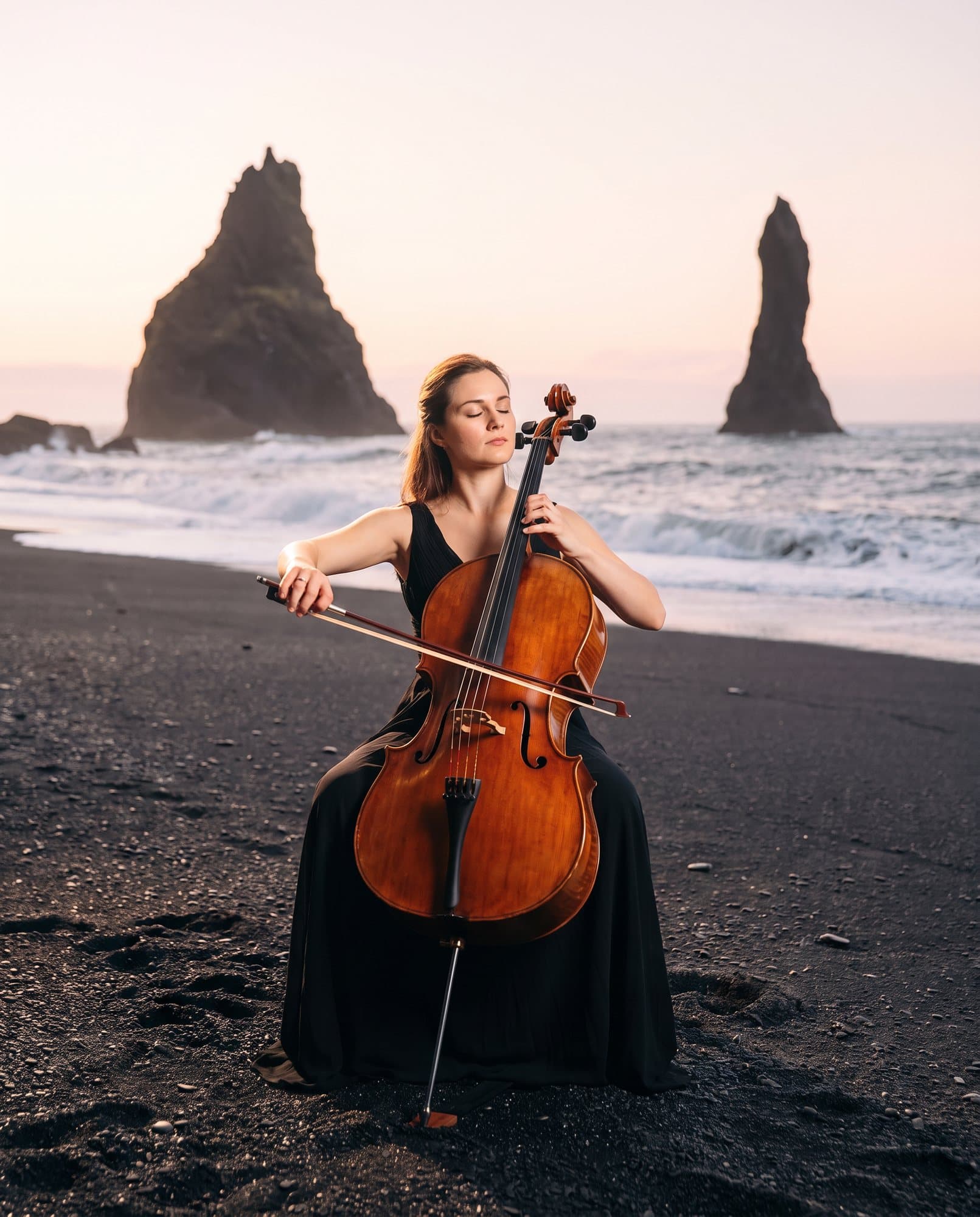 Swapped: A cellist playing on a black sand beach at dawn, moved from an empty concert hall